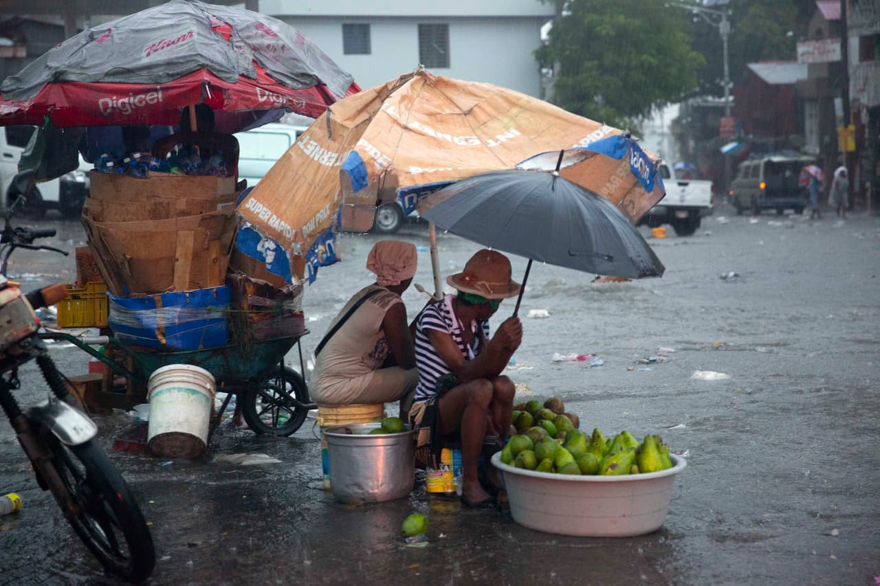 Vendedores ambulantes en las calles de Puerto Prince en Haití se protegen de las lluvias causadas por Laura. 
<br>
<br>En Haití, al menos cinco personas murieron en Haití este domingo por las lluvias torrenciales y deslizamientos de tierras causados por la tormenta tropical Laura, según un nuevo balance parcial de la Dirección de Protección Civil.