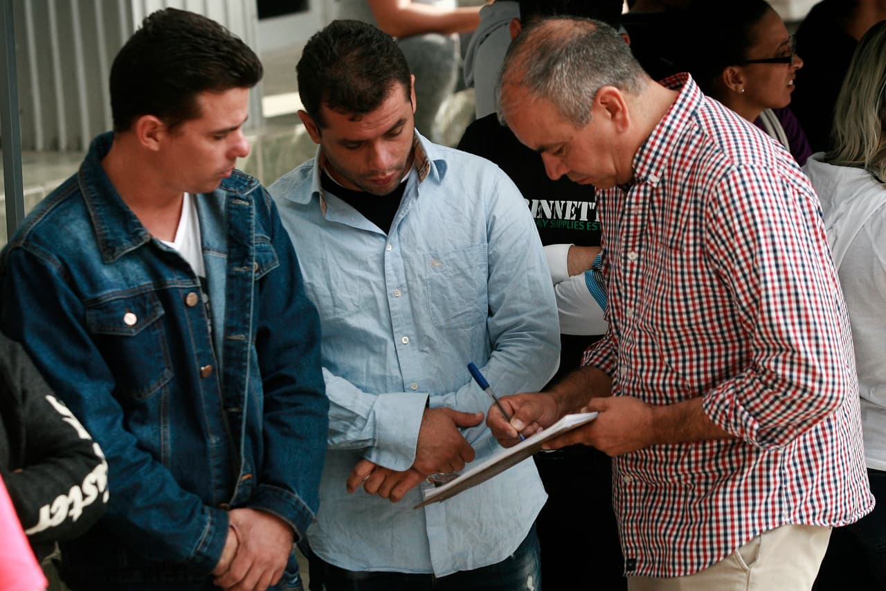 Al principio las personas eran organizadas con pulseras de plástico, pero desechadas porque muchas personas las estaban vendiendo o falsificando. En esta foto del 29 de abril de 2019, migrantes mientras son registrados por funcionarios de inmigración mexicanos en el puente internacional Paso del Norte.
