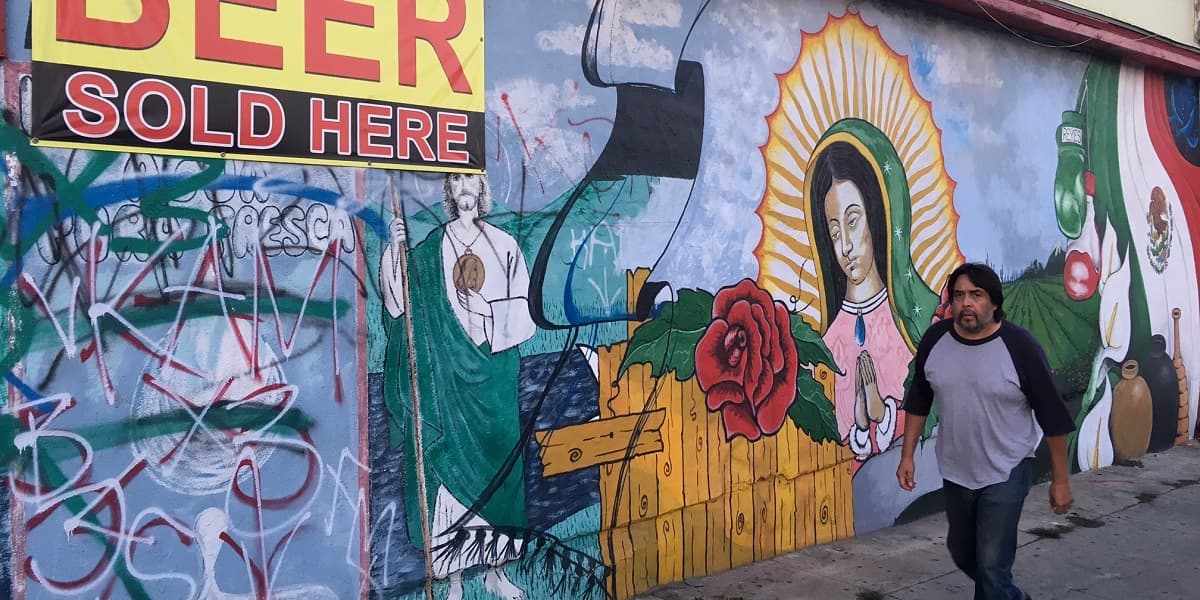 Ajena a los daños del grafiti, una Virgen de Guadalupe adorna la fachada de un negocio de Boyle Heights, en el este de Los Ángeles, California.