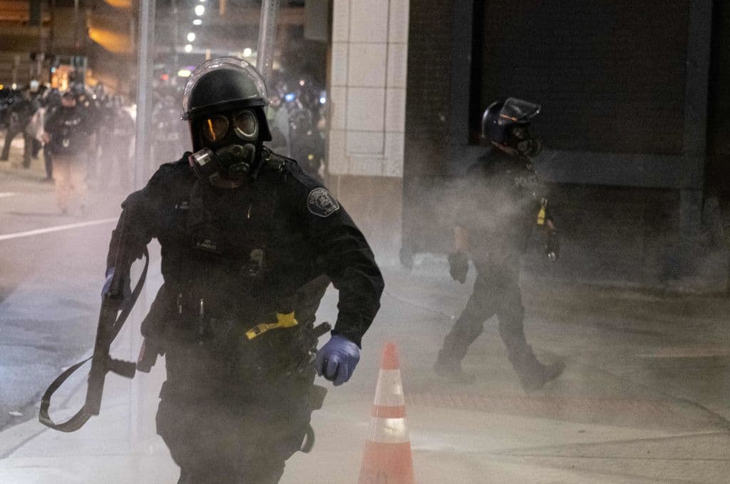 Un oficial de policía carga contra los manifestantes disperasando gas pimienta en Detroit, Michigan, donde un joven de 19 años fue asesinado por un sospechoso que huyó. La policía investiga el caso.