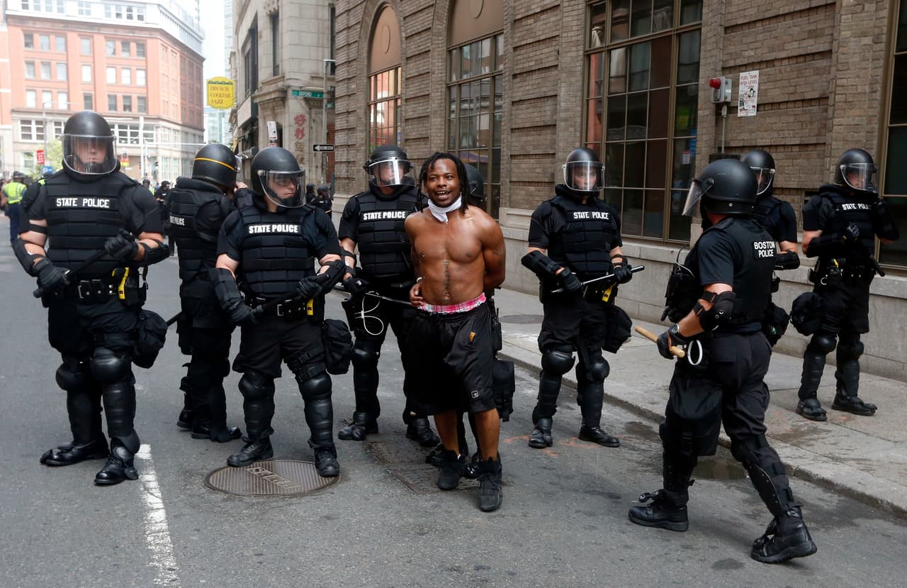 <b>La policía escolta a un hombre que participaba en la contraprotesta</b>. Estimaciones iniciales indican que unas 15,000 personas habrían participado en la manifestación contra el odio.