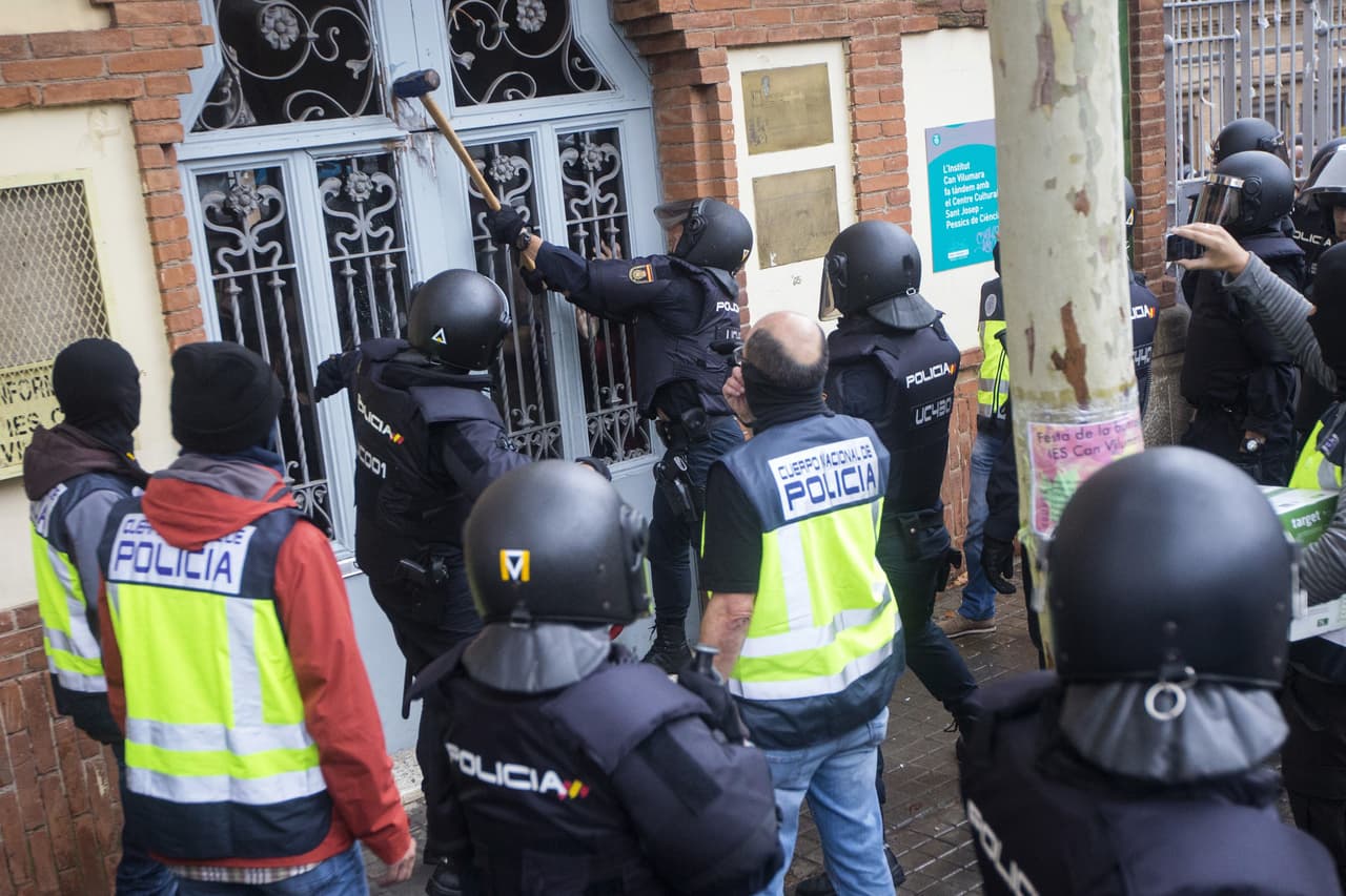 Agentes antidisturbios de la Policía Nacional a las puertas del Instituto Can Vilumara de L'Hospitalet de Llobregat. Policía Nacional y Guardia Civil han desplegado a sus agentes en varios colegios electorales de Barcelona para impedir el referéndum del 1-O, suspendido por el Tribunal Constitucional.