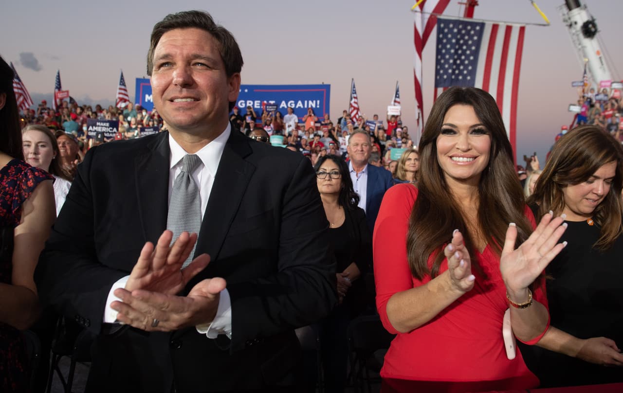 Sin mascarillas, el gobernador de Florida, Ron DeSantis (izquierda) y Kimberly Guilfoyle (derecha), presidenta de finanzas de la campaña del presidente de los Estados Unidos, Donald Trump. Ambos aplauden en el mitin del Aeropuerto Internacional Orlando Sanford.