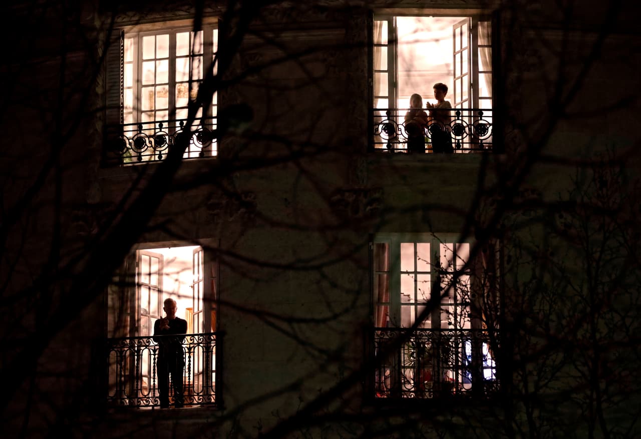 Parisinos aplauden desde sus balcones a los empleados de atención médica. Quien sale de casa en Francia, puede ser multado.