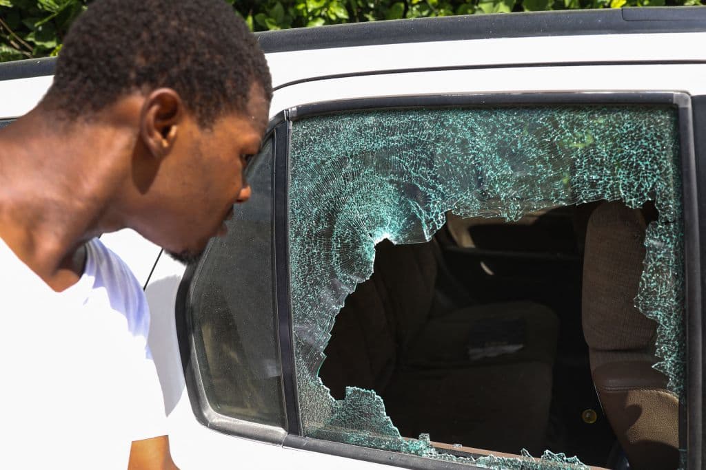En la imagen un hombre contempla el cristal de un vehículo 
<b>estallado por las balas </b>en el exterior de la residencia presidencial donde se cometió el asesinato. 
<br>
<br>