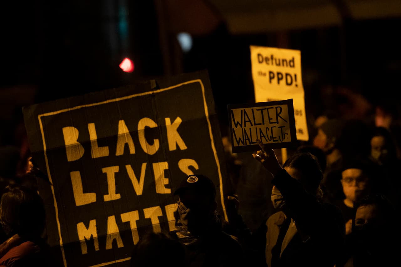 Los manifestantes sostienen carteles que dicen "LAS VIDAS NEGRAS IMPORTAN", "Walter Wallace JR". y DEFUND PPD "mientras se reúnen en protesta cerca del lugar donde Walter Wallace, Jr. fue asesinado por dos oficiales de policía el 27 de octubre de 2020 en Filadelfia, Pensilvania. Las protestas estallaron después del tiroteo mortal de 
<a href="https://www.univision.com/local/philadelphia-wuvp/segunda-noche-de-saqueos-y-vandalismo-en-filadelfia-luego-del-asesinato-de-walter-wallace">Wallace Jr</a>, de 27 años, quien Los agentes de policía de Filadelfia afirmaron que estaba armado con un cuchillo.