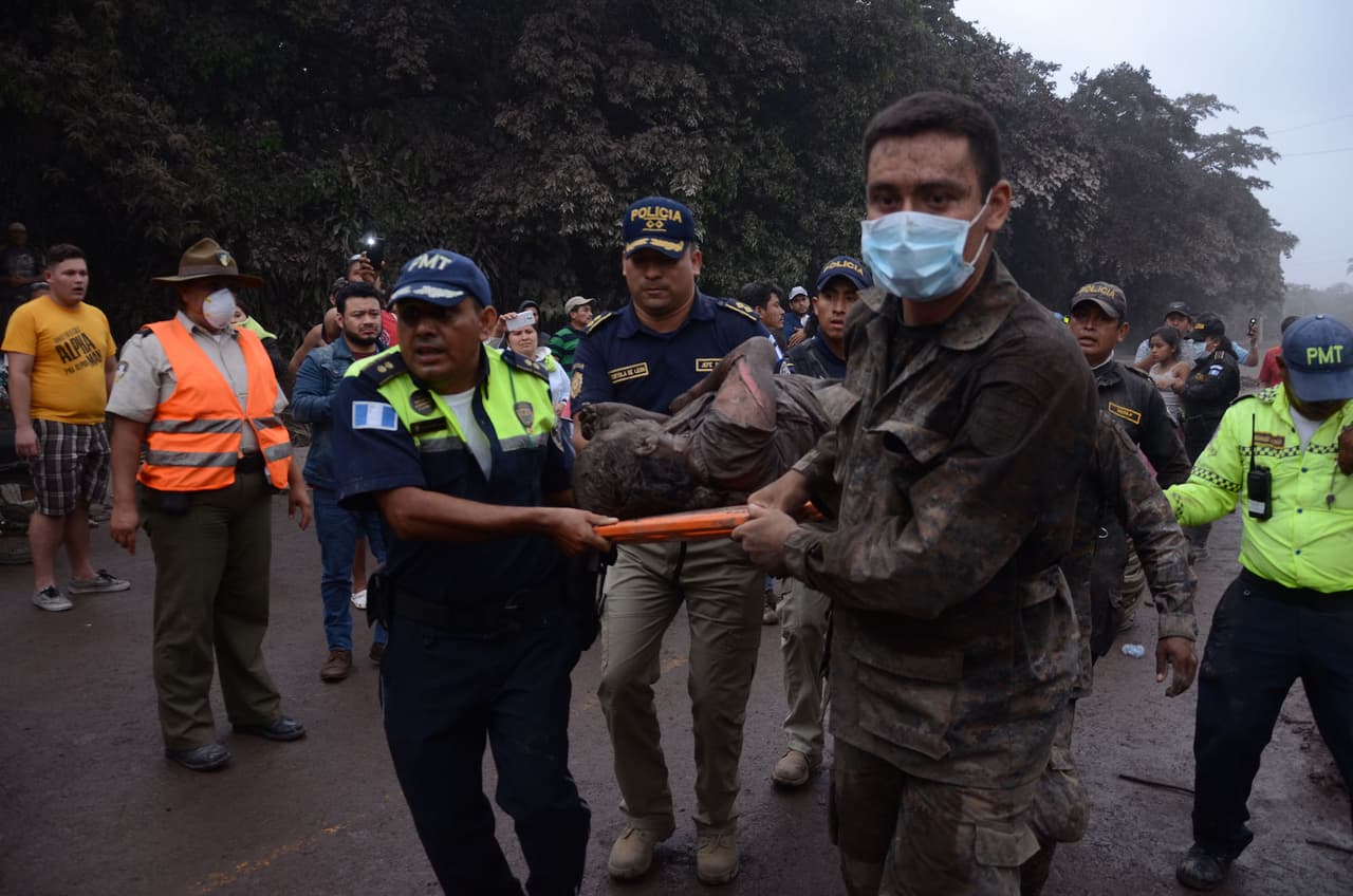 A group of rescuers in Guatemala carry a wounded victim in El Rodeo, Escuintla.
