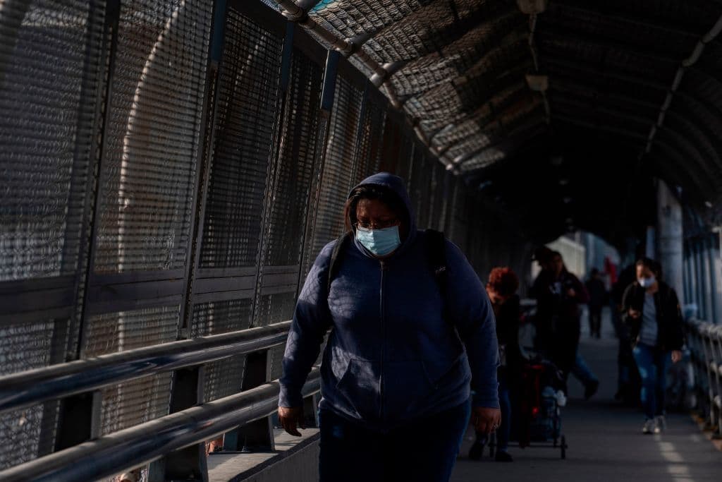 Una mujer cruza el puente internacional entre El Paso y Ciudad Juárez. Aunque ambas ciudades tienen órdenes de que sus residentes permanezcan en casa, muchos son trabajadores esenciales que viven de un lado y trabajan del otro. Por eso aún siguen cruzando.