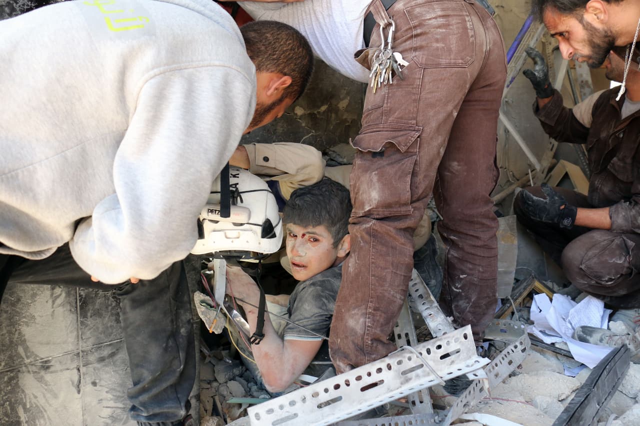 La organización Defensa Civil de Siria rescata a un niño de los escombros de un edificio atacado por las fuerzas del gobierno el 30 de mayo de 2016. Según la ONU, al concluir 2015, el conflicto había causado 250,000 muertes, y había 7,6 millones de personas desplazadas internamente y 4,6 millones refugiadas en otros países.
<br>
