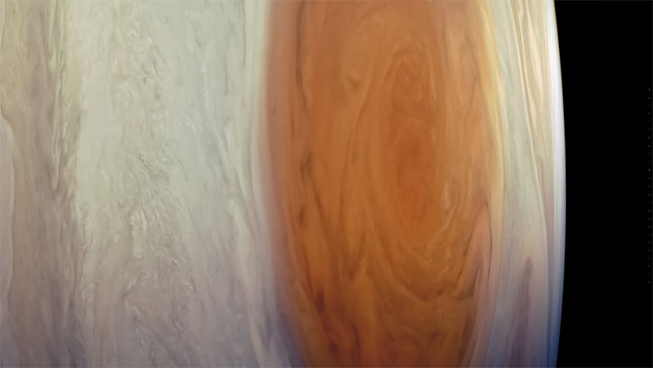 La nave espacial Juno de la NASA capturó esta vista detallada de la característica más reconocible de Júpiter, su ‘Gran Mancha Roja’. Los instrumentos de la nave indican que este remolino gigante e interminable se extiende mucho más profundamente en la atmósfera del planeta que lo que los científicos suponían, a unas 300 millas (500 kilómetros) por debajo de las cimas de las nubes. 
<br> 
<br>