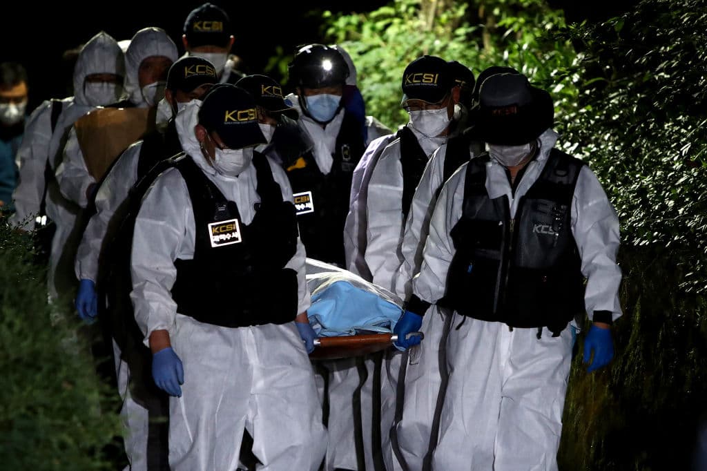 Policías trasladan el cuerpo del alcalde de Seúl encontrado en un parque al norte de la ciudad.