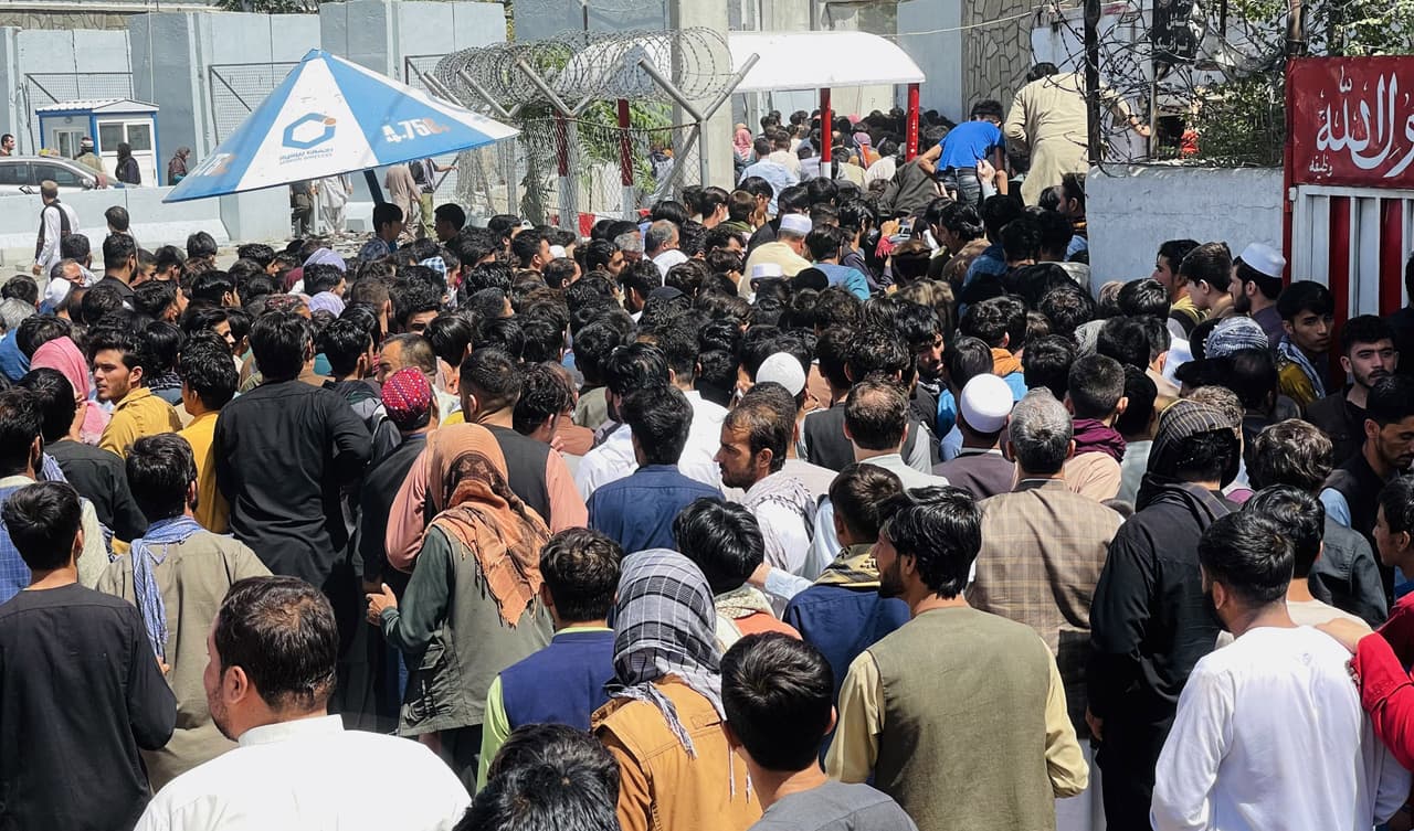 La multitud entrando al aeropuerto de Kabul. videos publicados en redes social durante la noche muestran a personas peleándose para entrar en un avión de carga, ya repleto.