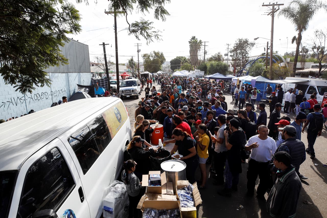 No hay cifras precisas sobre la cantidad de personas que han decidido retornar a sus comunidades de origen, pero se sabe que aún son más los que siguen llegando a Tijuana. La fotografia muestra la enorme fila que los migrantes deben hacer frente al refugio para obtener comida.