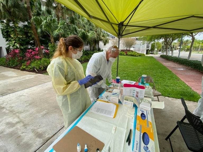 Un voluntario de salud pública recolectando muestras de sangre en Miami Beach con un miembro del equipo de rescate de Miami Dade como parte de la investigación de anticuerpos covid-19 por la Universidad de Miami, 6 de abril de 2020.