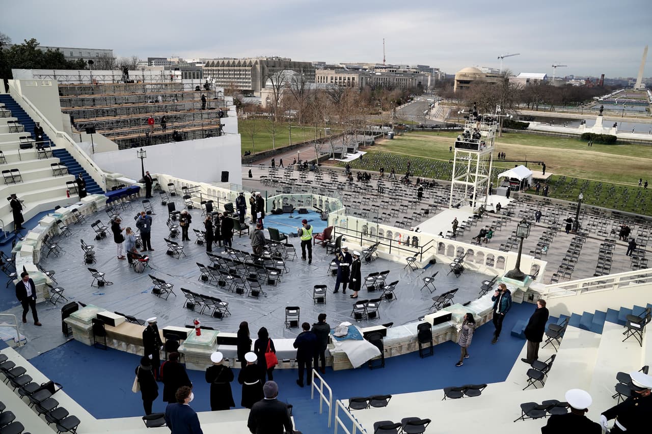 Un grupo de trabajadores pone a punto el espacio donde ocurrirá la juramentación, que tendrá una asistencia limitada. El FBI advirtió que extremistas pro-Trump, posiblemente en poder de explosivos, son una amenaza para Washington DC en los próximos días.