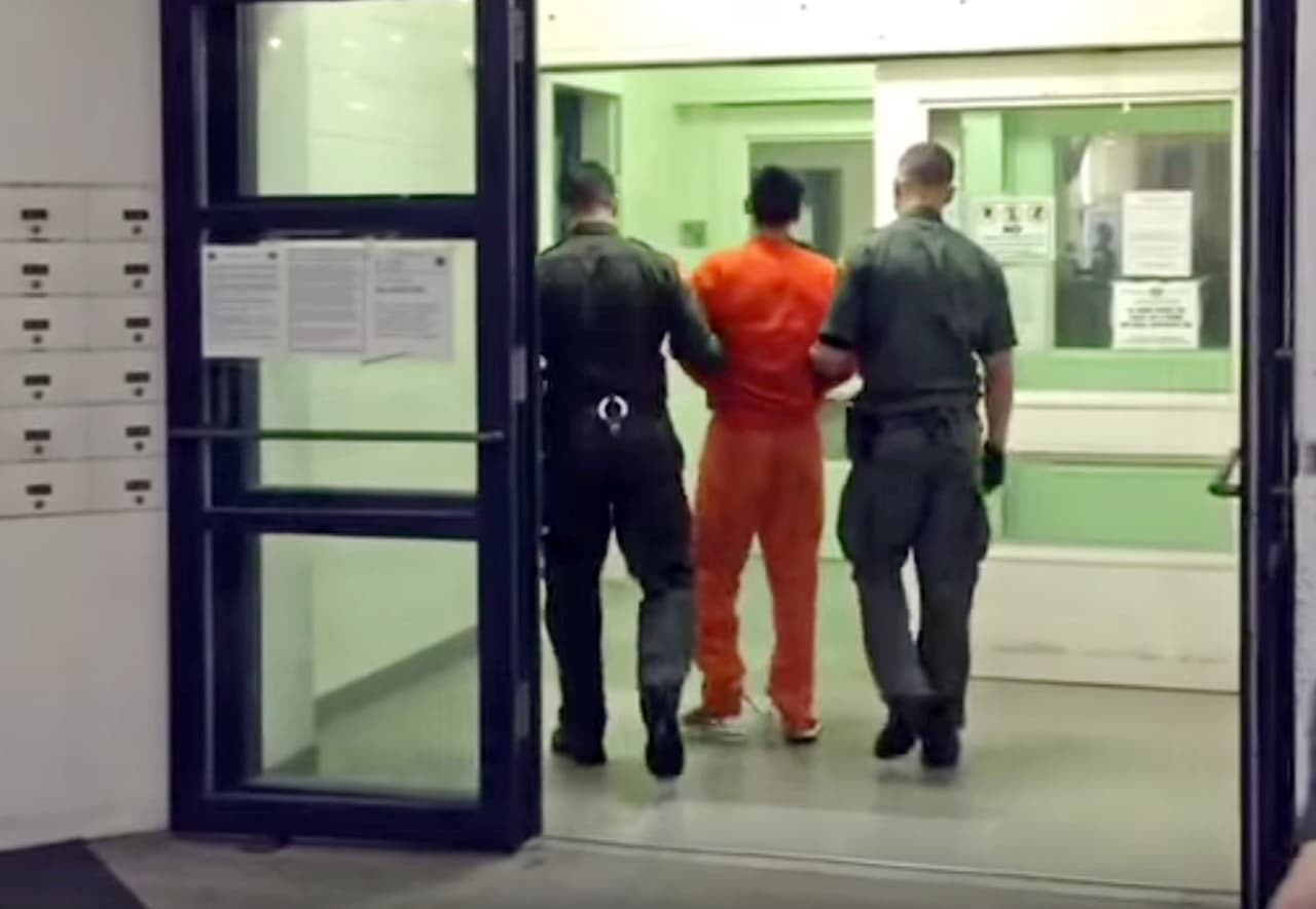 En este fotograma del video proporcionado por el Departamento del Sheriff del Condado de Orange, los agentes escoltan a Jonathan Tieu de regreso a la Cárcel Central de Hombres en Santa Ana, California, en las primeras horas de la mañana del domingo 31 de enero de 2016.