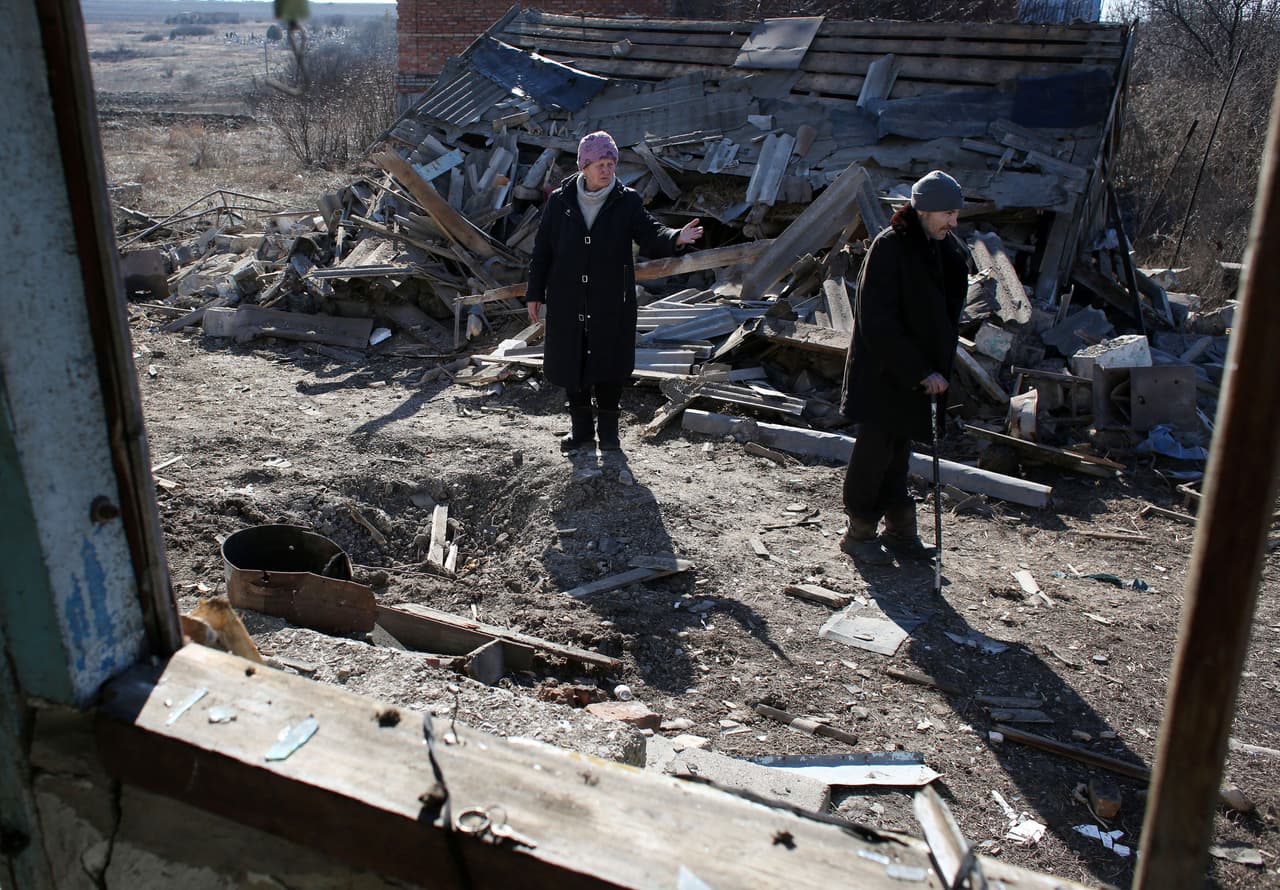 Los residentes frente a su casa destruida después de un bombardeo en Donetsk, este 20 de febrero de 2022. 
<b>La resolución del conflicto, prevista en los acuerdos de Minsk de 2015, está en un punto muerto, ya que el gobierno ucraniano y los separatistas se acusan de no respetarlos. </b>
<br>
<br>Aunque se instauraron varias treguas, quedaron obsoletas por las repetidas violaciones de las partes en conflicto.