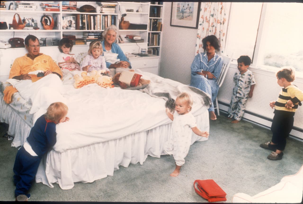 Los esposos Bush en su cama junto a seis de sus catorce nietos en Washington.