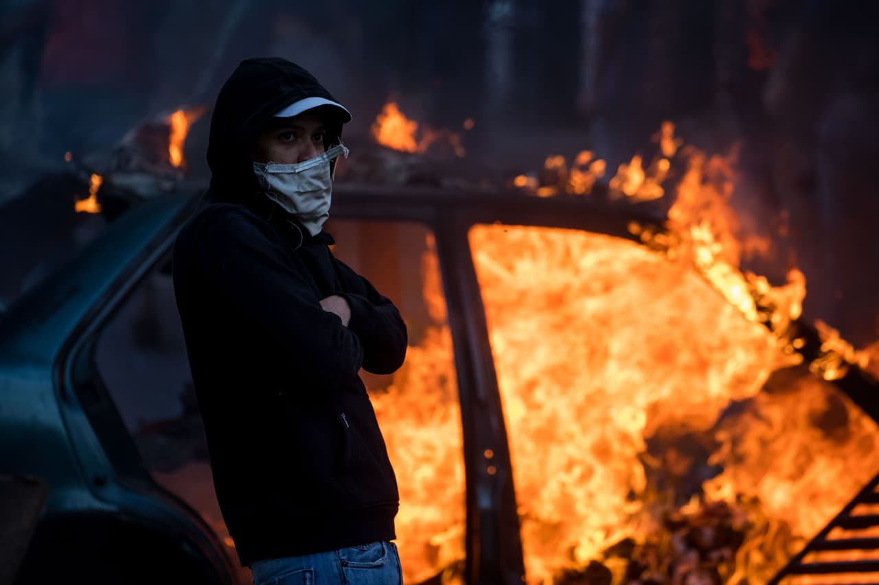 Un joven con la cara semi cubierta protesta este lunes en Cotiza. Las imágenes recuerdan a las manifestaciones que han acompañado a Maduro desde el inicio de su gobierno, solo que en esta ocasión ocurrieron en Cotiza, una zona popular del oeste de la capital, y no en barrios de clase media.