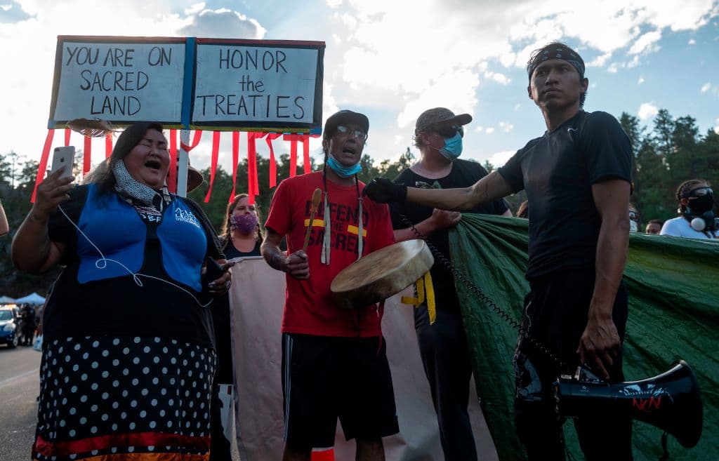 Las protestas estaban dirigadas a la presencia de Trump en un lugar sagrado e intentaron bloquear con vehículos la vía hacia el monte, pero fueron retirados por la Policía y la Guardia Nacional encargadas de resguardar la zona, según imágenes difundidas en redes sociales.