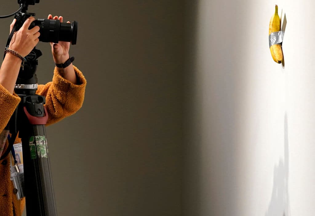 <b>El concepto detrás de "Comedian"</b> :
<br>
<br>
<b>Sencillez provocativa:</b> Cattelan es conocido por sus obras cargadas de humor, crítica social y una visión irónica del mercado del arte. Según el artista, había estado trabajando con la idea de una banana como objeto artístico durante más de un año, explorando su forma y cómo exhibirla.
<br>
<b>Crítica al mercado del arte:</b> La pieza plantea preguntas sobre los límites del arte contemporáneo y el valor que se le asigna a los objetos cotidianos cuando se presentan en un contexto artístico.
<br>
<b>El título:</b> El nombre "Comedian" podría interpretarse como un guiño a la reacción que esperaba generar: risas, incredulidad y debates sobre lo que cuenta como arte.
<br>
