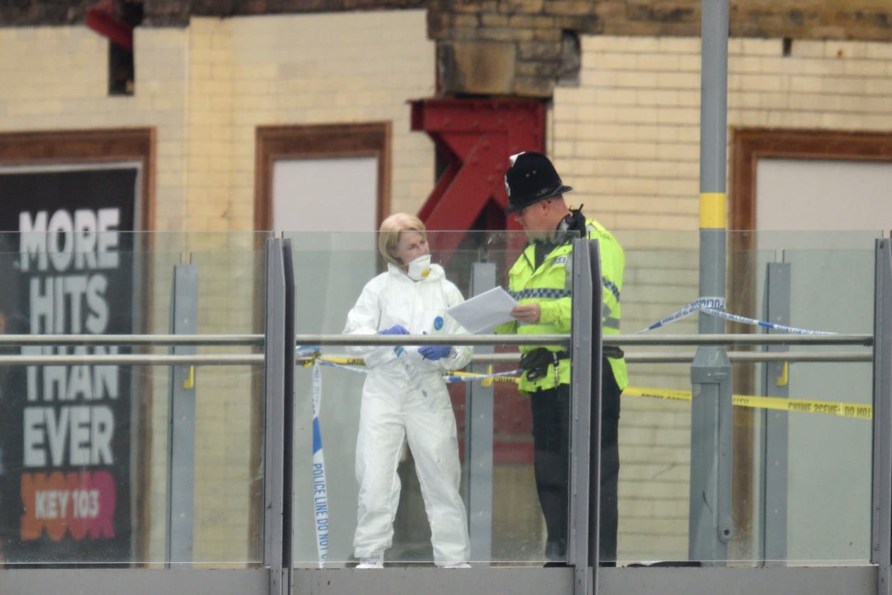 Un oficial forense (a la izquierda) recoge pruebas en los alrededores del estadio Manchester Arena tras el ataque terrorista en Manchester. Este se convirtió en el atentado más mortífero de Gran Bretaña en más de una década.