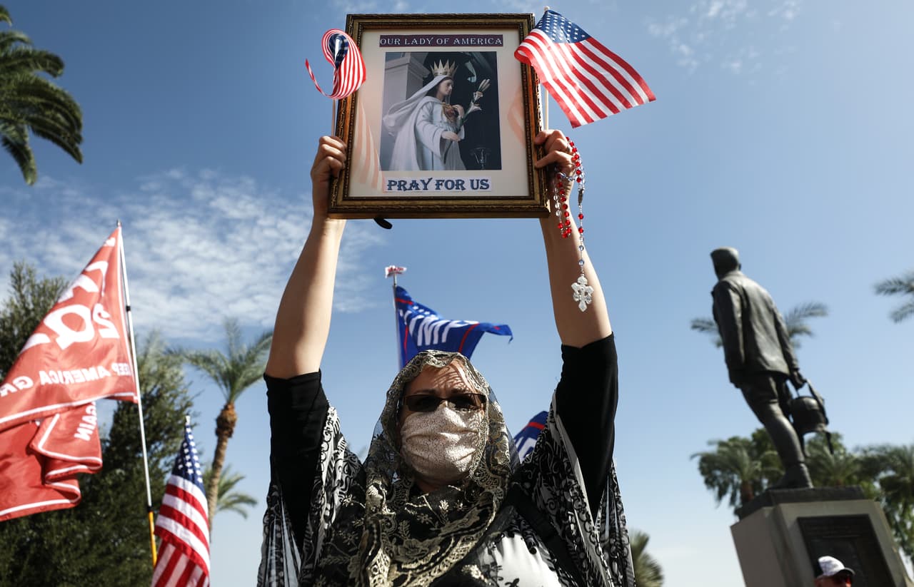 Con el cuadro de una virgen una partidaria del presidente Donald Trump se manifiesta en "Stop the Steal" frente al Capitolio del Estado el 7 de noviembre de 2020 en Phoenix, Arizona.