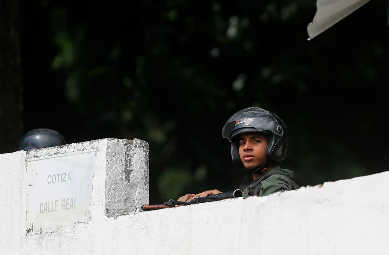 Un soldado de la Guardia Nacional vigila la calle trasera del comando donde este lunes un grupo de soldados intentó sublevarse en contra del gobierno de Nicolás Maduro y llamó a la gente a salir a la calle para protestar.