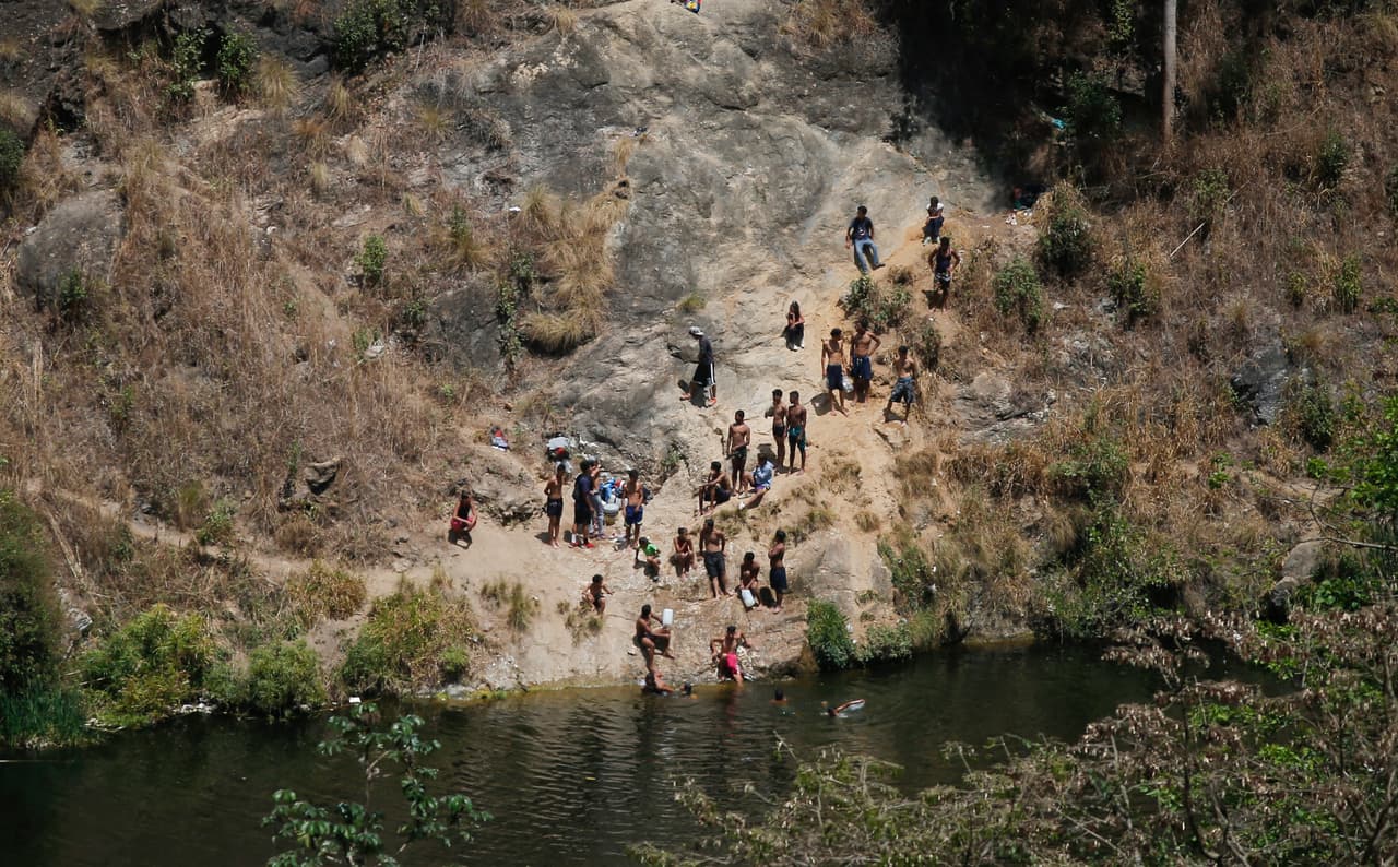 La gente se refresca en una laguna y aprovecha para llenar recipientes en Caracas. Desde el 7 de marzo hasta la fecha, la ONG Foro Penal reportó 324 detenciones, de las cuales 124 ocurrieron durante protestas por el apagón y otras 200 en los saqueos que se dieron en diferentes ciudades del país.
