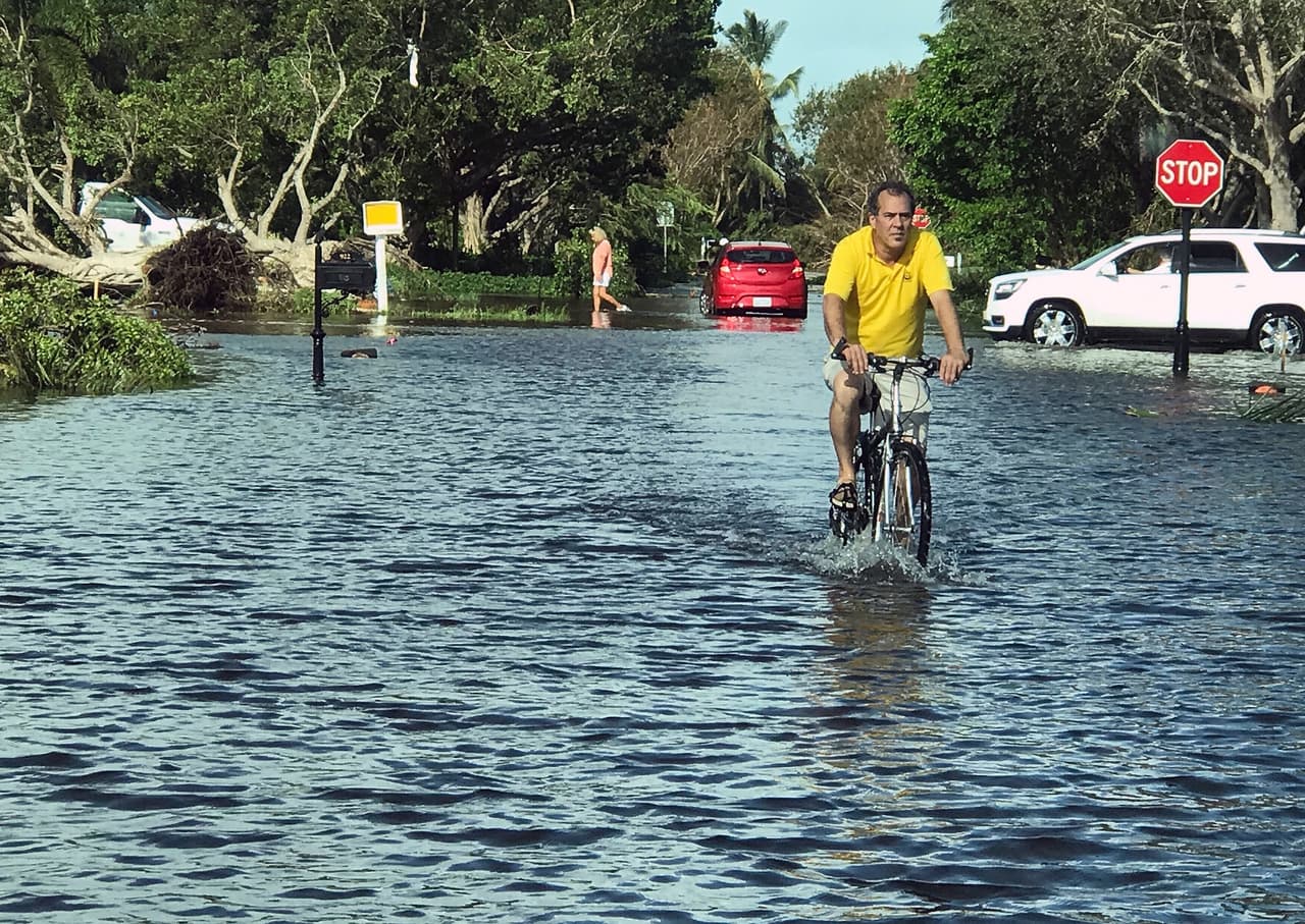 Naples como Venecia. Un hombre decide salir en su bicicleta a circular por las calles inundadas de la ciudad.