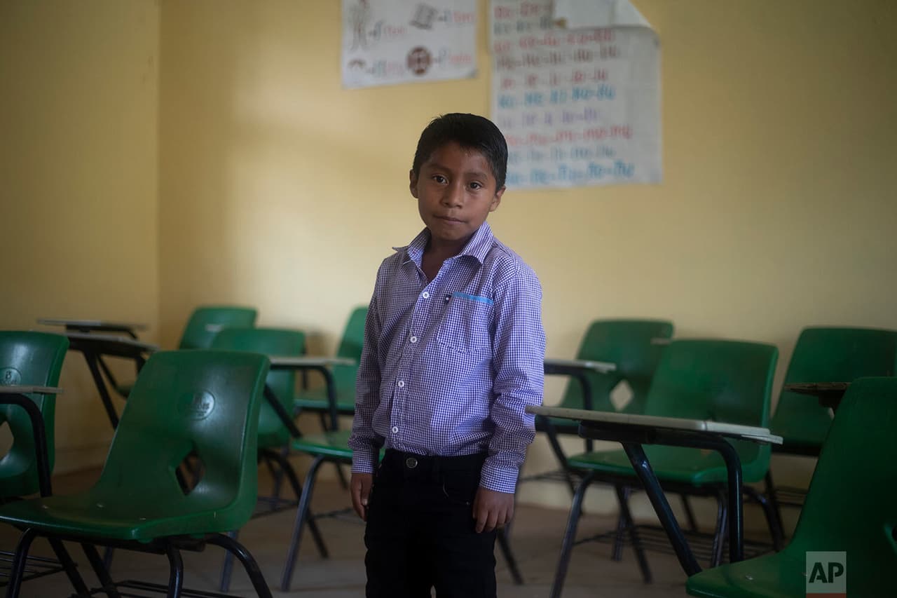 Héctor Vásquez posa para un retrato dentro de su antiguo salón de clases en la escuela Nuevo Yibeljoj. 
<b>Vásquez es uno de los 12 hermanos que trabajan en los campos de café todos los días</b> en lugar de solo los fines de semana, mientras su padre los ayuda con las tareas escolares que les dejan los maestros.