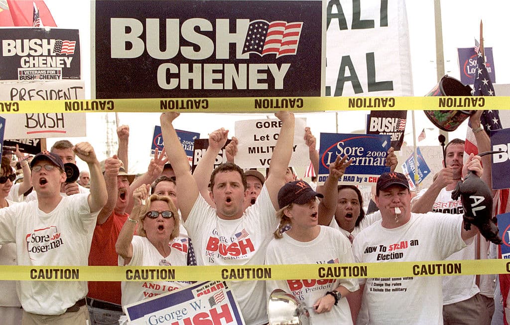 Partidarios del candidato presidencial republicano George W. Bush corean consignas y se burlan de los demócratas frente al Centro de Operaciones de Emergencia del Condado de Palm Beach el 26 de noviembre de 2000 en West Palm Beach, Florida.
