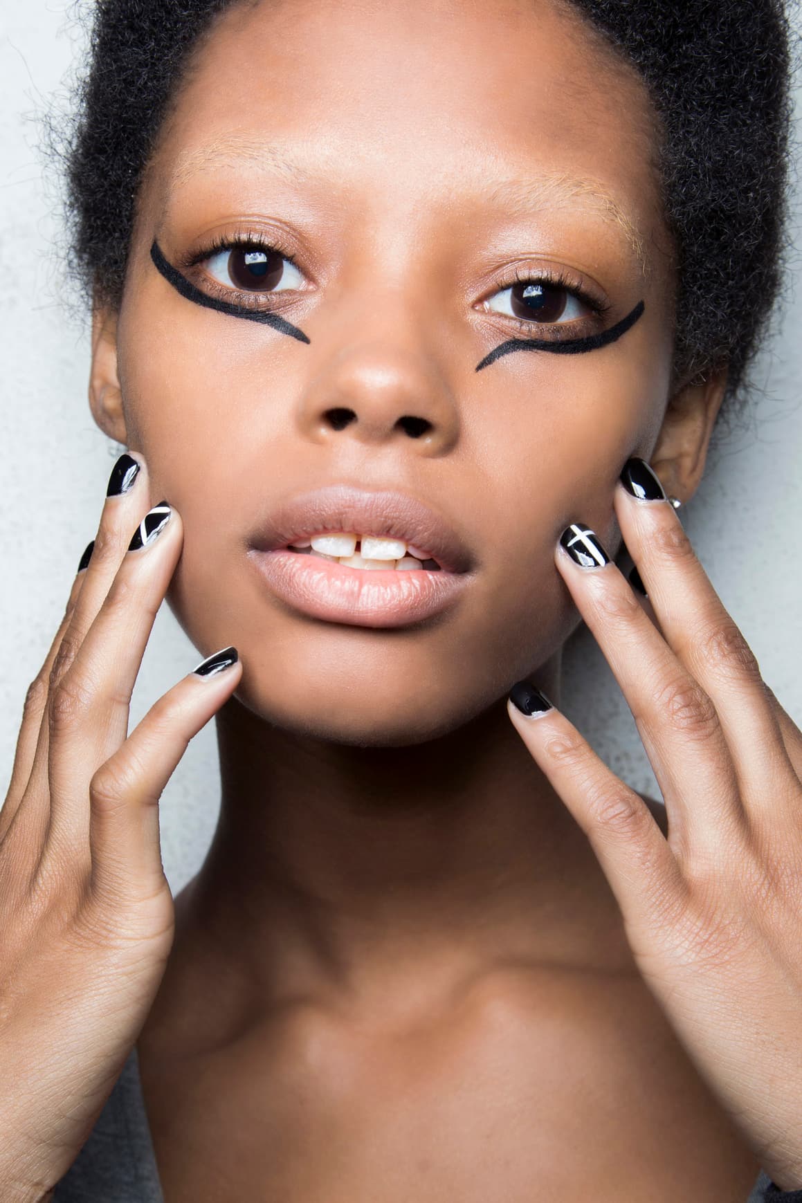 Estos mismos símbolos los puedes realizar sobre las uñas oscuras, por lo que deberás hacer los trazos con esmalte blanco o nude. No tienes que decorar todas las uñas, los motivos los puedes hacer únicamente en algunas de ellas.