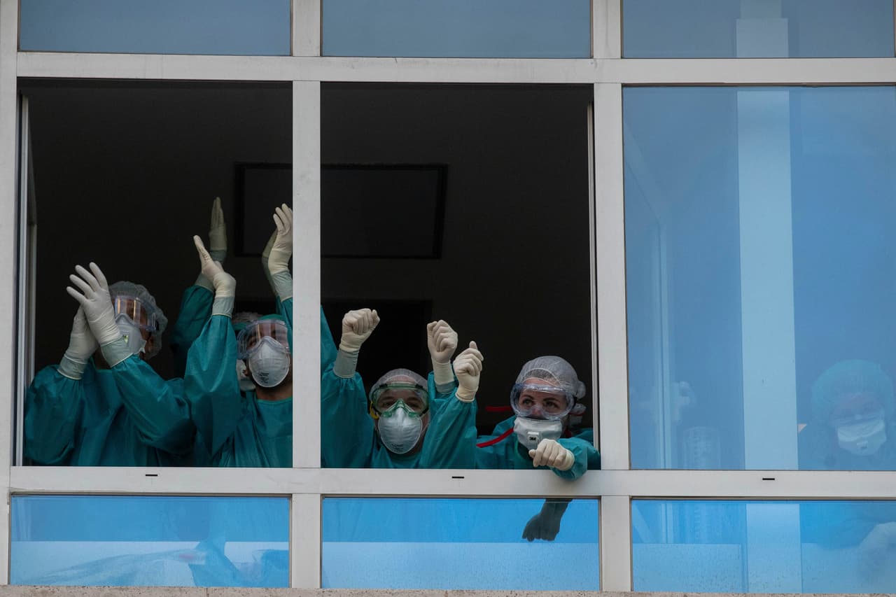 Médicos y enfermeras de un hospital de Madrid aplauden de vuelta a los vecinos que los reconocen desde las ventanas de sus apartamentos. Las manifestaciones públicas de agradecimiento comenzaron a popularizarse en Italia y España, los primeros países en entrar en crisis por el coronavirus aparte de China. 15 de abril.
