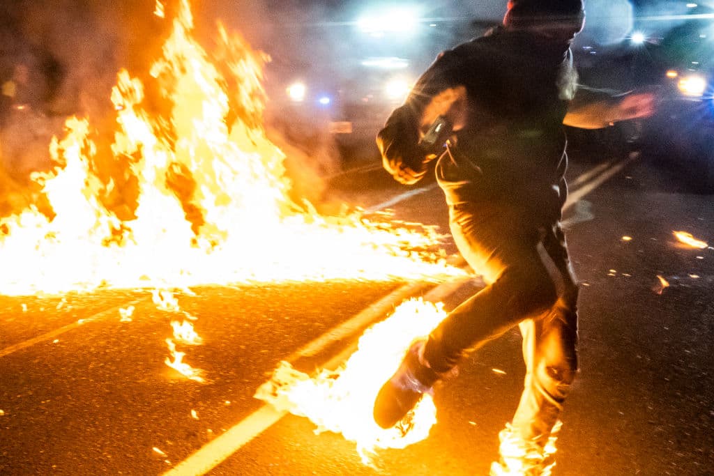 Tras el lanzamiento de un cóctel molotov desde la multitud, uno de los propios manifestantes fue alcanzado por el fuego en sus piernas y tuvieron que intervenir varias personas hasta conseguir apagarlo.