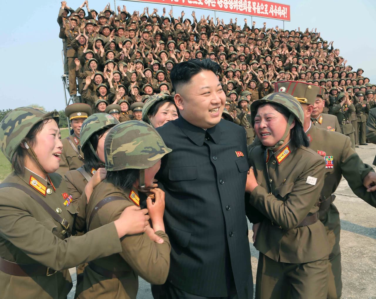 Mujeres de la unidad 851 del ejercito de Corea del Norte abordan a Kim Jong Un, durante una prueba de lanzamiento de cohetes. 24 de abril de 2014.