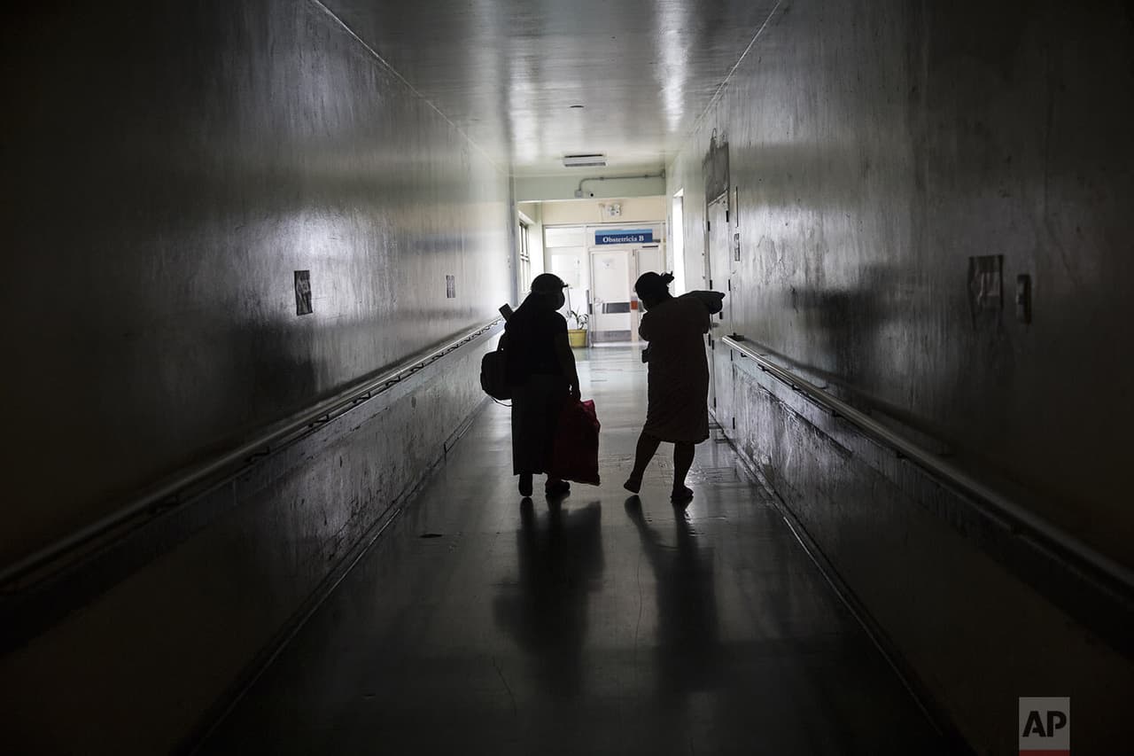 Con la ayuda de su madre,
<b> una mujer y su bebé recién nacido salen del instituto. </b>
<br>
