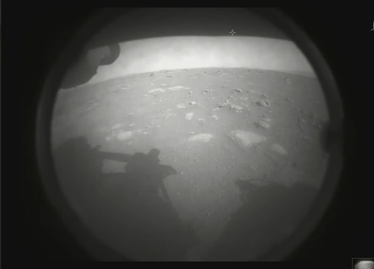 <b>La primera foto de Perseverance.</b> Esta fue la primera imagen que envió este aparato desde Marte, a pocos minutos de tocar suelo. Todo el hardware del Perseverance debe evaluarse para asegurarse de que no sufrió ningún daño durante la violenta a través de la atmósfera marciana hasta el suelo.
<br>