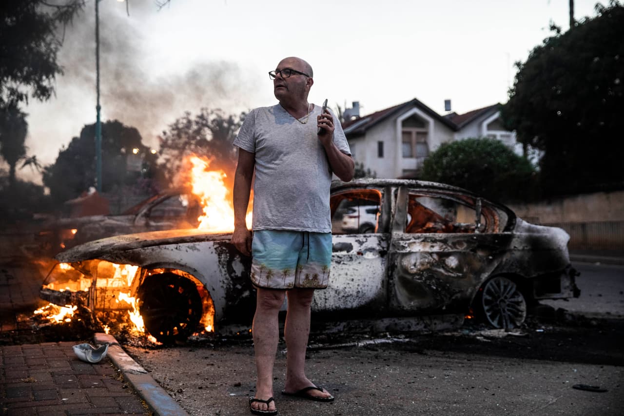 Jacob Simona, residente de Lod, Israel, de pie junto a su auto en llamas durante los enfrentamientos entre palestinos y policías israelíes el 11 de mayo. La violencia se desató en Jerusalén hace un poco más de un mes, cuando la policía israelíe chocó con los manifestantes palestinos que protestaban los intentos de desalojo por la fuerza de varias familias.
<br>
