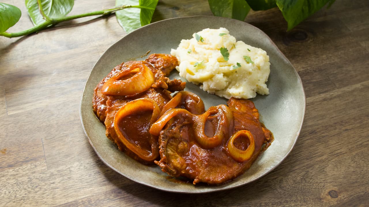 Chuletas de puerco adobadas y encebolladas