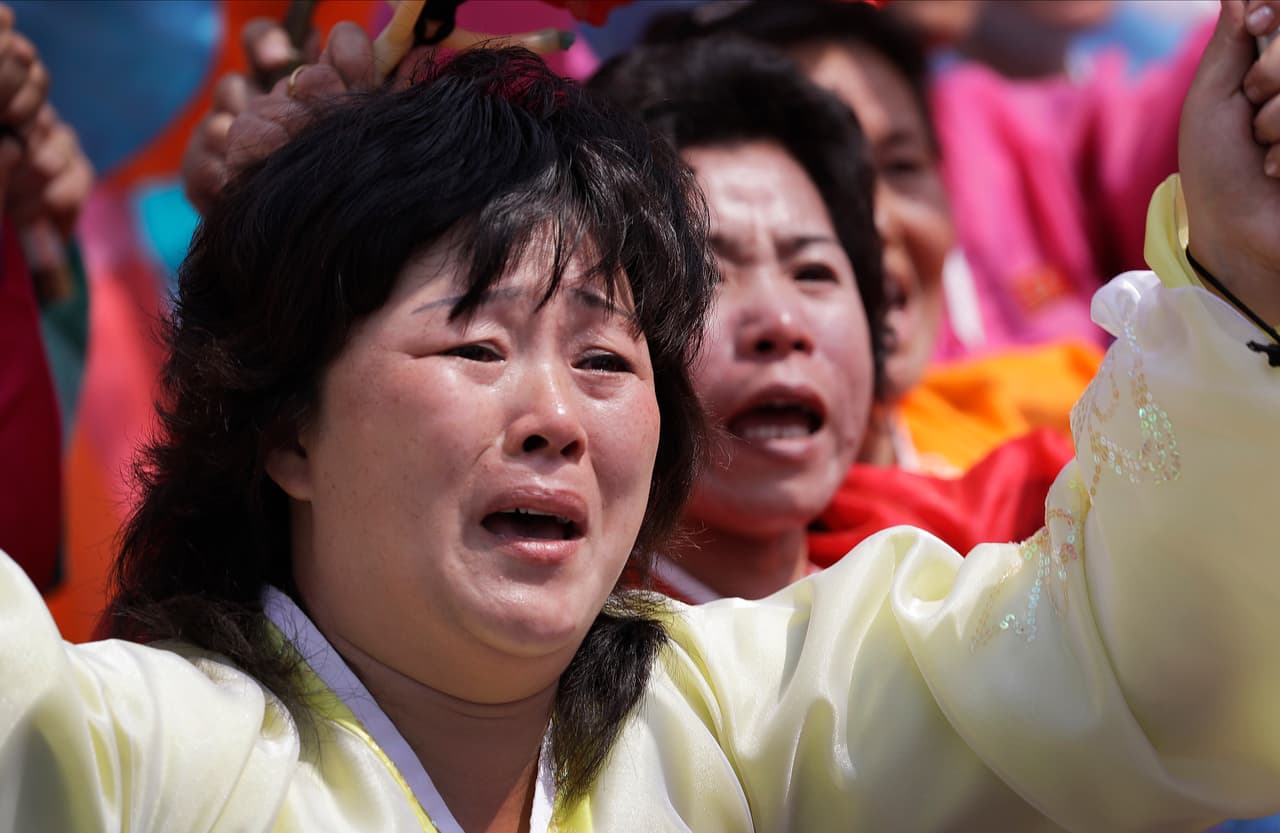 Una mujer llora mientras la marcha pasa frente al lugar donde se encuentra el líder Kim Jong-un.