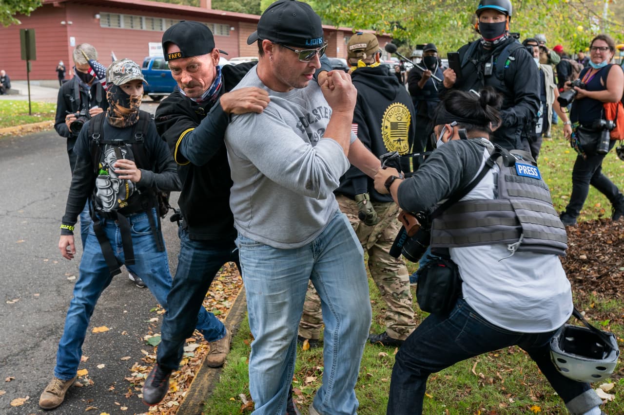 Un miembro de Proud Boys
<b> agredió al periodista independiente Justin Katigbak (derecha) </b>durante un mitin, acusándolo de pertenecer a Antifa.