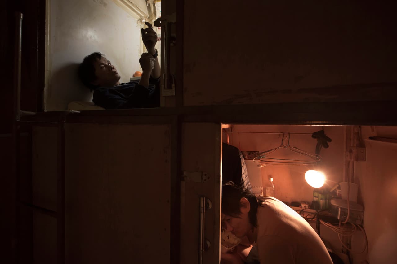 Dos vecinos de 'casas ataúd': Yeung, en la habitación superior y Lui, en la inferior. 
<br>