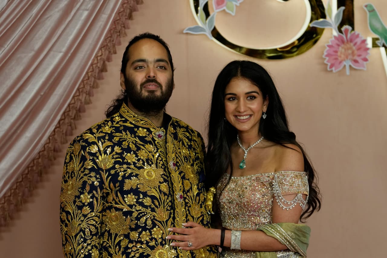 El hijo menor de Ambani, Anant Ambani, y Radhika Merchant.
<br>
<br>La novia, Radhika Merchant, también de 29 años, es hija del magnate farmacéutico Viren Merchant y es la directora de marketing de su empresa, Encore Healthcare, según Vogue.
<br>
<br>Los críticos de Ambani dicen que su empresa se ha basado en conexiones políticas durante los gobiernos liderados por el Partido del Congreso en los años 70 y 80, y bajo el gobierno del primer ministro Narendra Modi después de 2014.
<br>
<br>