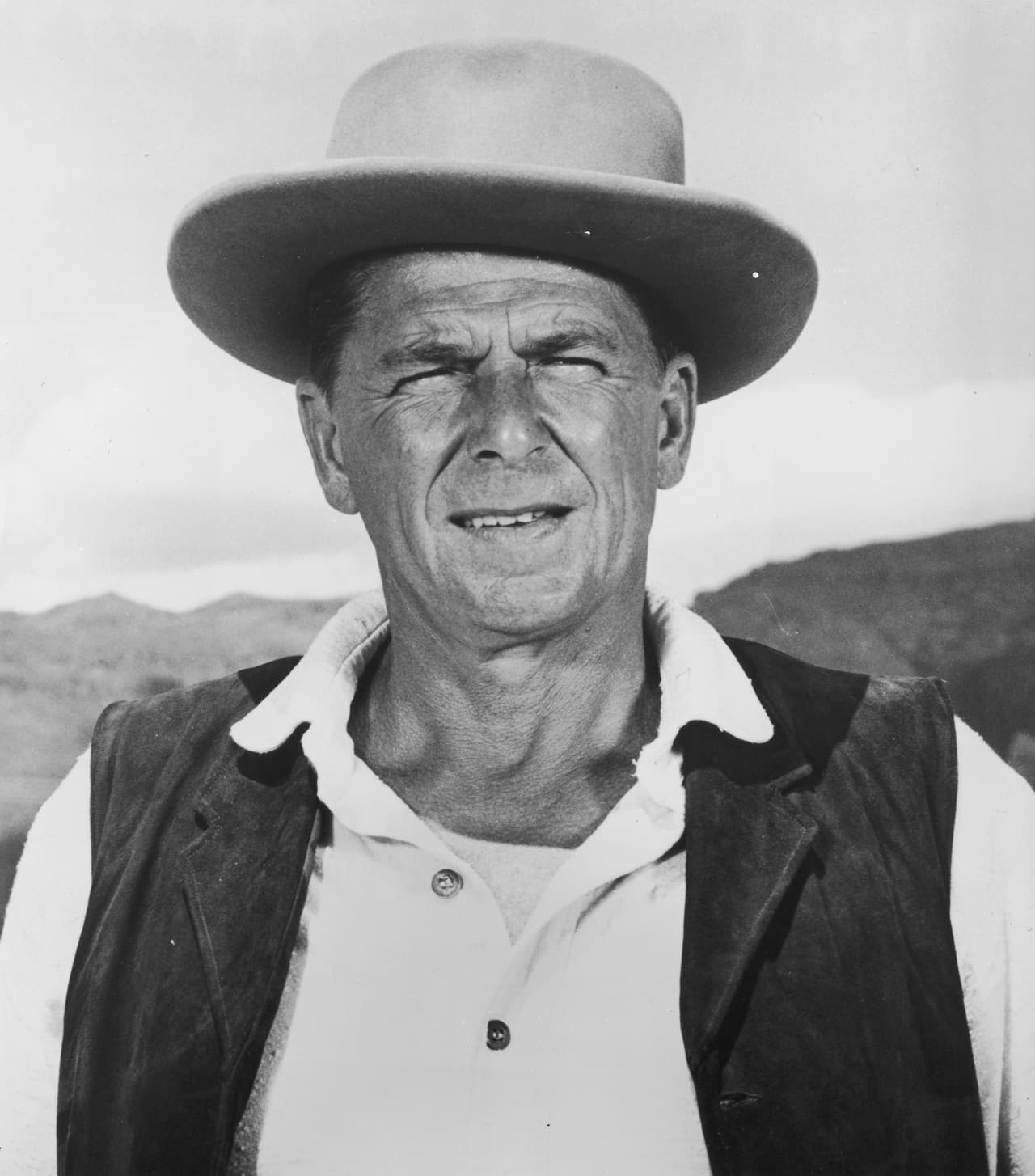 <a href="http://www.history.com/topics/us-presidents/ronald-reagan">Atleta, salvavidas en la playa, actor y presidente</a>. Todo eso fue Ronald Reagan (1911–2004). En una de sus películas hace el papel de un hombre que 
<a href="https://www.youtube.com/watch?v=K217rguXSXI">pierde sus piernas</a> y grita "¿dónde está el resto de mí?", una frase que utilizó para titular su autobiografía. En su administración, entre 1981 y 1989, terminó la Guerra Fría, trabajó en la creación de empleos, bajó los impuestos, el gasto gubernamental y la inflación. Además, fue un estratega militar hábil: mejoró las relaciones con la Unión Soviética, envió bombarderos a Libia cuando atacaron a unos soldados estadounidenses en un bar de Berlín, mantuvo el flujo de petróleo con la ayuda de barcos de la US Navy durante la guerra Irán-Irak y sobrevivió a un intento de asesinato en 1981. La fotografía pertenece a la serie de televisión "Death Valley Days", de 1966, 14 años antes de ser presidente. 
<br>
<br>
<br>