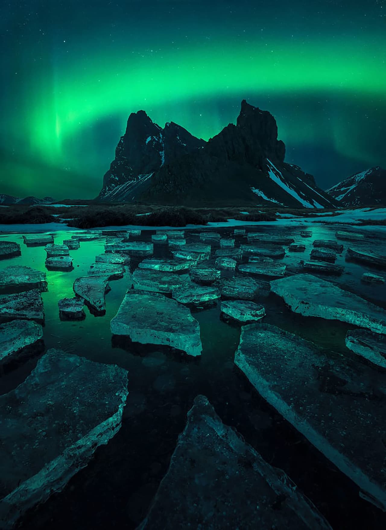 <b>‘Abrazando a la dama verde’</b>
<br>
<br>
<b>Sureste de Islandia</b>
<br>
<br>“Encontré un primer plano interesante con reflejos de color y esperé a que apareciera la aurora. De repente empezó a bailar exactamente donde quería, ¡justo encima de la ladera de la montaña!”, contó el autor.
<br>