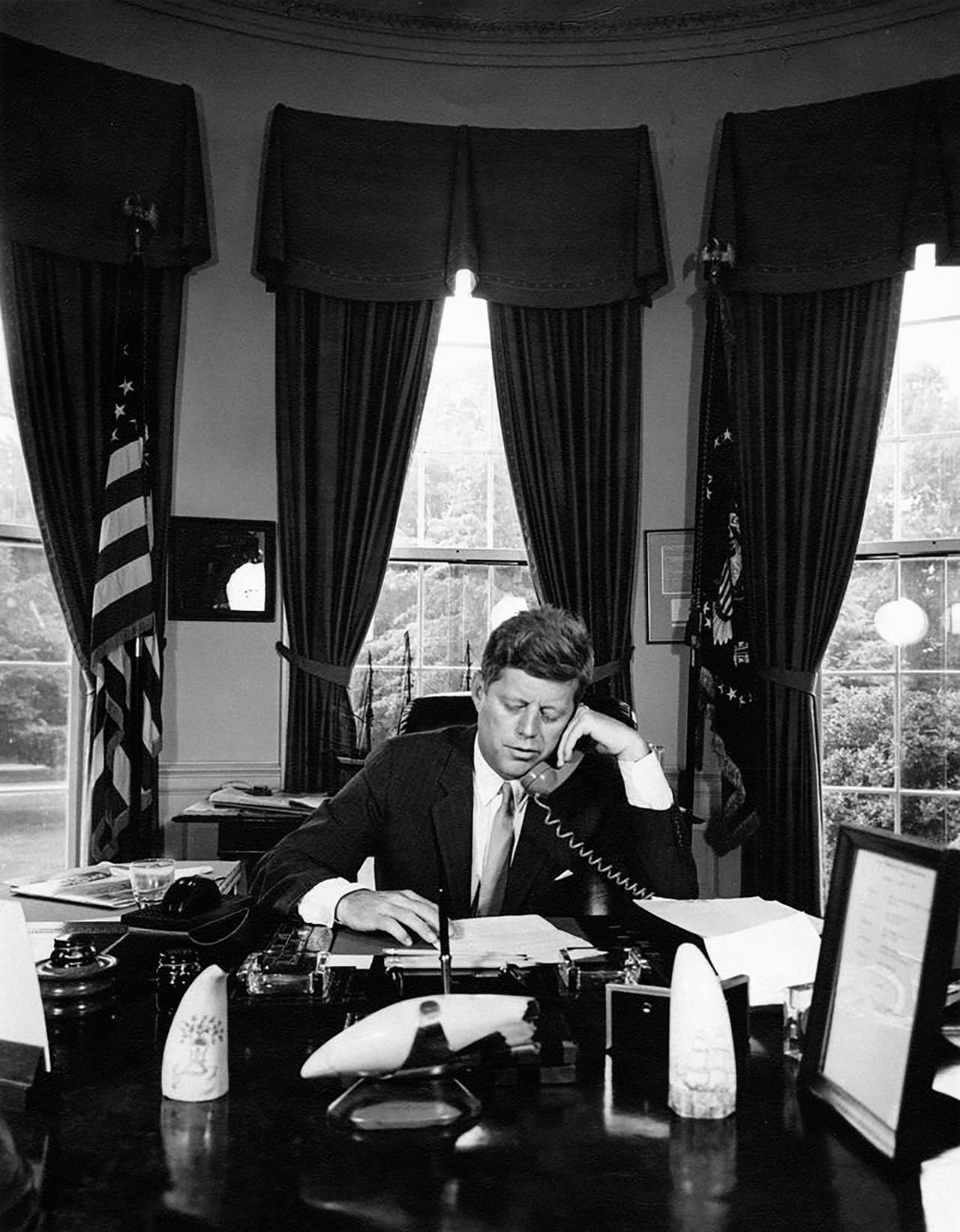 La lucha por los derechos civiles fue uno de los puntos centrales de la breve gestión de JFK. Las acciones tomadas en 1962 en estados sureños, que incumplieron el dictamen de la Corte Suprema que ilegalizó la segregación racial, fueron intervenidas por autoridades federales al mando de JFK. La fotografía fue tomada en agosto de 1962, en la Oficina Oval de la Casa Blanca.
<br>