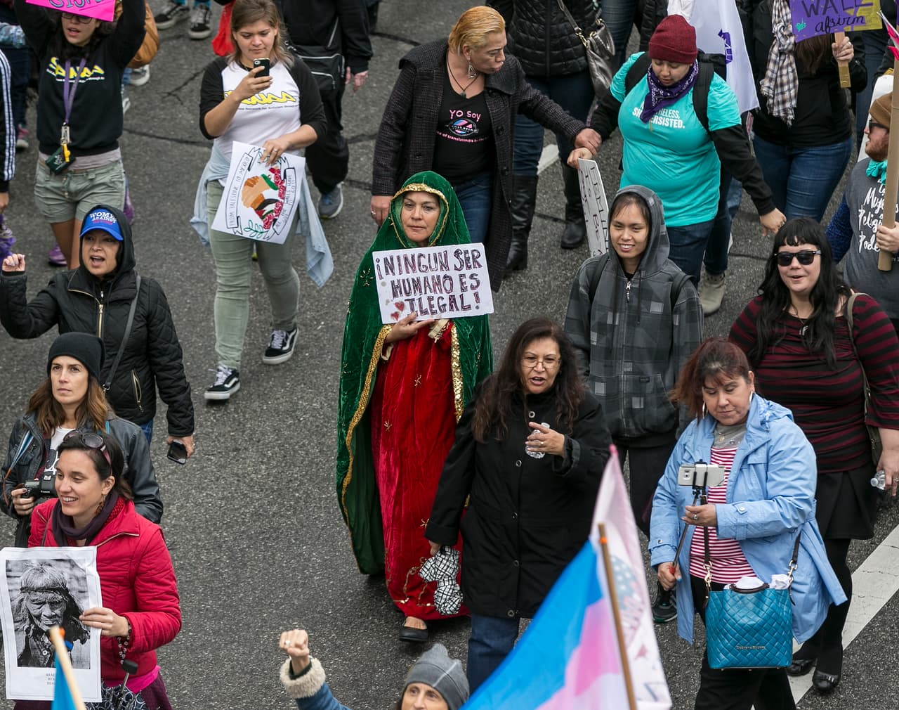 “Ningún ser humano es ilegal”, pronuncia el cartel de una mujer que se vistió como la Virgen de Guadalupe.