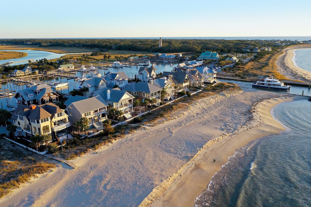 <b>Número 2: Bald Head Island</b>. Bald Head Island es una de las mejores ciudades costeras de Carolina del Norte. En primer lugar, la única forma de llegar es mediante un viaje en ferry de 20 minutos desde la cercana Southport. Lo que significa que, una vez que llegue allí, sentirás que has dejado atrás el ajetreo y el bullicio del "mundo real".