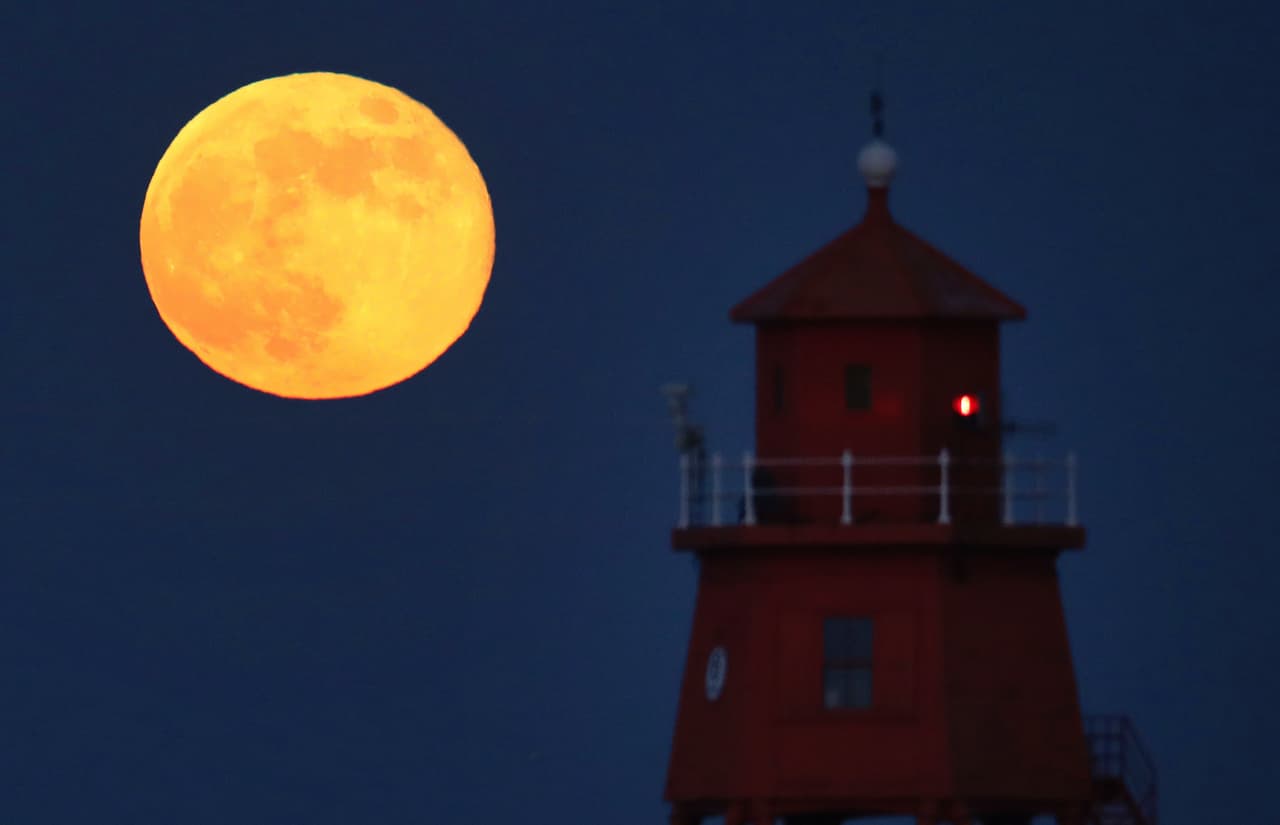 La Superluna de mayo de 2020 se levanta sobre el faro de Groyne en South Shields, en la costa noreste, el jueves 7 de mayo de 2020. ¿Por qué el nombre? 
<b>Cada mes del año tiene Luna llena, cuando se cumple el ciclo lunar de casi 28 días. Cada luna tiene un nombre. </b>